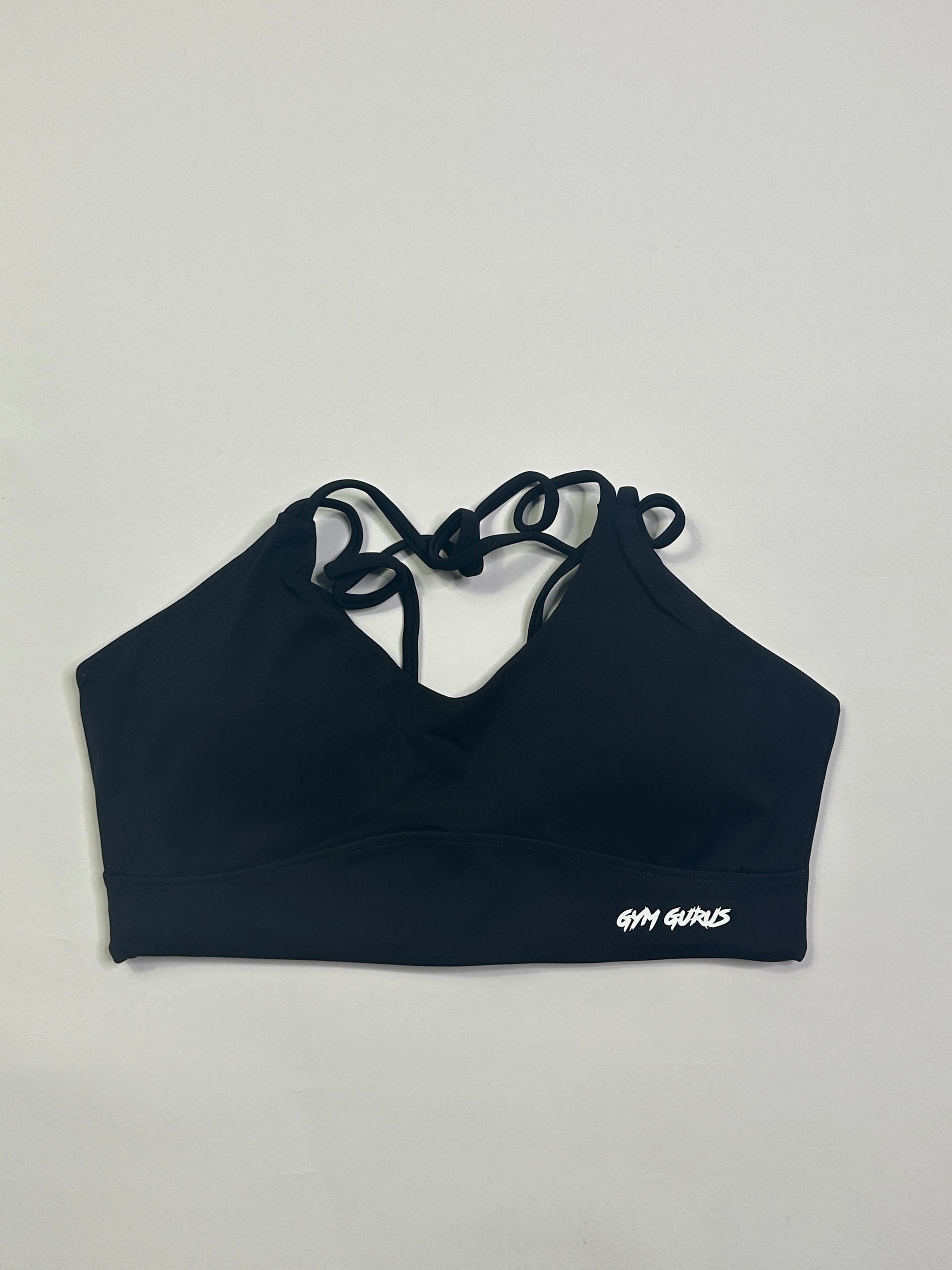 Black sports bra with lace-up sides on a light gray background